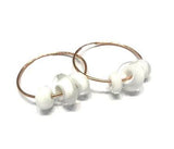 pair of rose gold hoop earrings with white beads